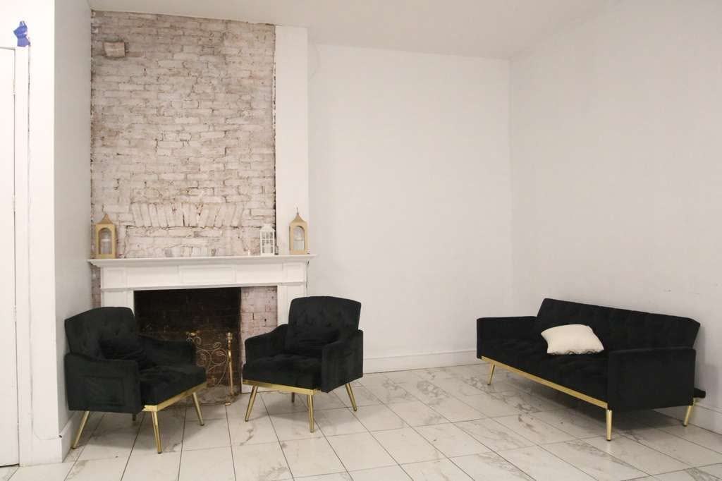 Fireplace lounge with black and gold seating at Elegance on Varet